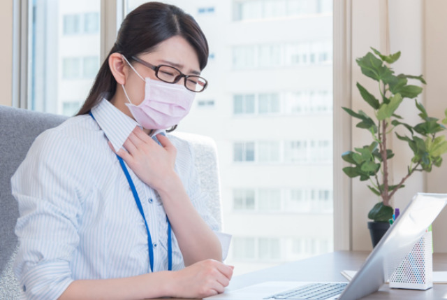 咳き込むマスク姿の女性